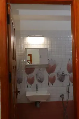 a bathroom with a sink and a mirror at Coimbatore's Chettinad Courtyard By Shivalaya Stays in Alāndurai