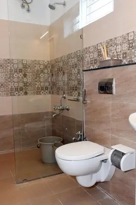 a bathroom with a toilet and a shower at Casa by the hills in Kotagiri
