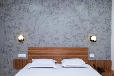 a bedroom with a bed with two white pillows at Balu Residency - A Business Class Hotel in Coimbatore