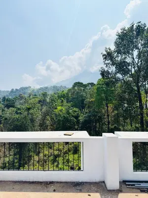 a white balcony with a view of the mountains at AYD-IN BY GREENLEAVES Resort in Vythiri
