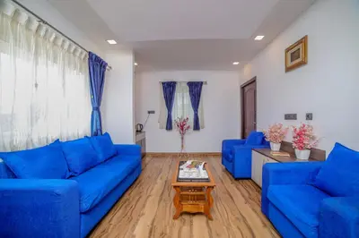 a living room with blue couches and a coffee table at Royal Crown in Kotagiri