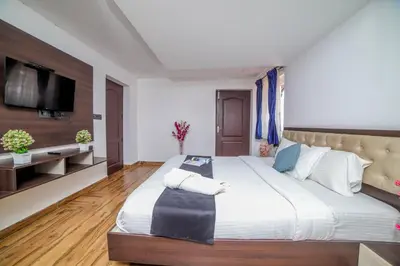 a large bedroom with a large bed and a flat screen tv at Royal Crown in Kotagiri