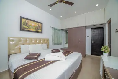 a bedroom with a large bed with two pillows on it at Royal Crown in Kotagiri
