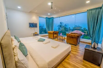 a living room with a large bed and a large window at Royal Crown in Kotagiri