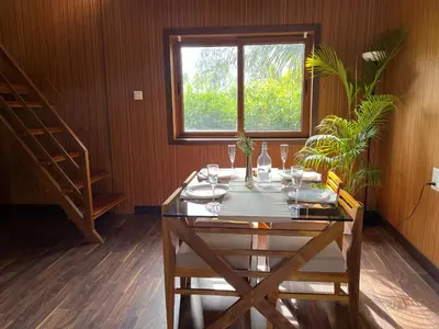 a dining room with a table and a window at Jungle flare in Hampāpura