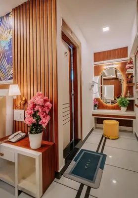 a lobby with a table and a vase of flowers at Excellency Airport Hotel in Angamali
