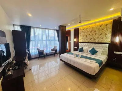 a bedroom with a large bed and a television at Mysore Elite in Mysore
