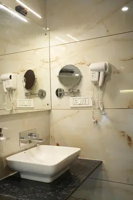 a bathroom with a sink and a mirror at Mysore Elite in Mysore
