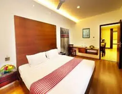 a bedroom with a large bed with a wooden headboard at Horizon Heights Apartment in Coimbatore