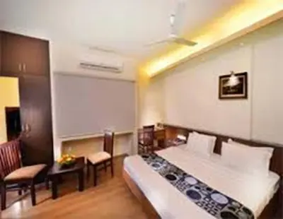 a hotel room with a bed and a table and chairs at Horizon Heights Apartment in Coimbatore