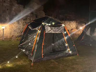 a tent is set up on the grass at night at The Plum Castle in Kodaikānāl