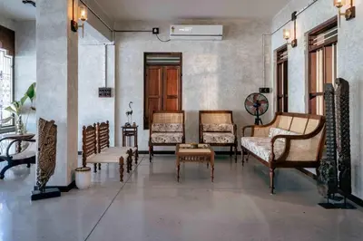 a living room with chairs and a table at Reverie in North Paravur