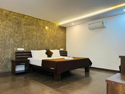 a bedroom with a bed and a wall at 2 Empire One Bedroom with Common Pool in Wayanad