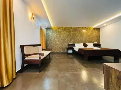 a bedroom with a bed and a couch and a desk at 2 Empire One Bedroom with Common Pool in Wayanad