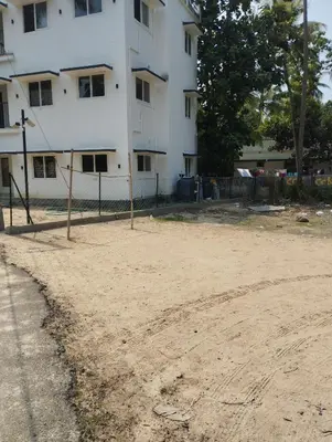 an empty dirt field in front of a building at Thrikarthika appartments in Guruvāyūr