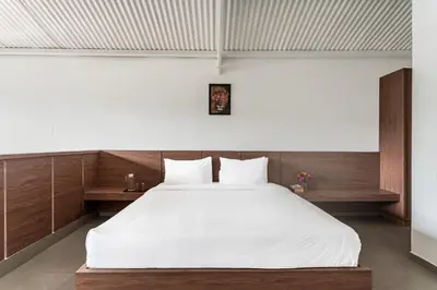 a bedroom with a large bed with white sheets at Finch,Kotagiri in Kotagiri