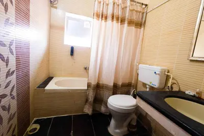 a bathroom with a toilet and a tub and a sink at Hotel DRG Heritage in Tiruppūr