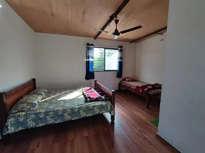 a bedroom with a bed and a window at Bandipur Jaguar Homestay in Bandipūr