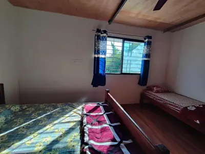 a bedroom with a bed and a window at Bandipur Jaguar Homestay in Bandipūr