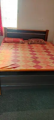 a large bed in a bedroom with a checkered at Bandipur Jaguar Homestay in Bandipūr