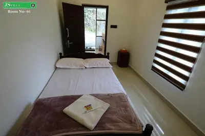 two beds in a room with a window at JS homes vattavada in Vattavada