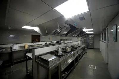 a large kitchen with stainless steel appliances in it at Ambal Regency in Pudukād