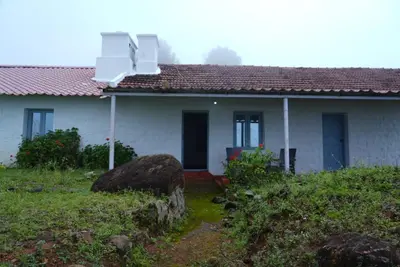 a white house with a red roof at Estate Bungalow with Waterfall, Mountain & Valley Views in Kotagiri