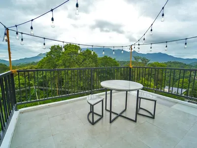 a table and chairs on a balcony with a view at Oasis Apartment with Pool in Vythiri in Vythiri