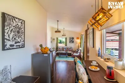 a kitchen and living room with a dining room at StayVista at Valley Whispers with BBQ & Bonfire in Ooty