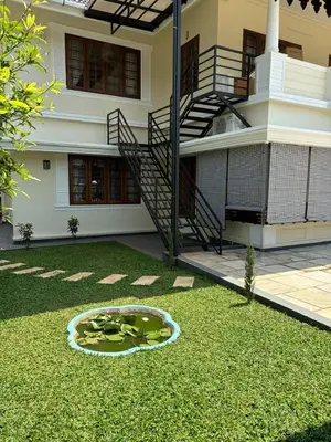 a building with a pond in front of a house at Serene Nest Apartment-Kochi Airport in Nedumbassery