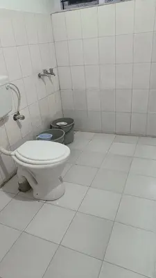 a bathroom with a toilet and two trash cans at Vi stays in Ooty