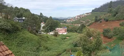 a view of a valley with houses on a hill at Vi stays in Ooty
