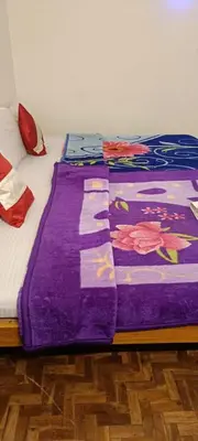 a bed with a purple blanket on top of it at Vi stays in Ooty