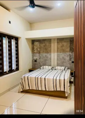 a bedroom with a bed and a ceiling fan at LINE Villas in Kodungallūr
