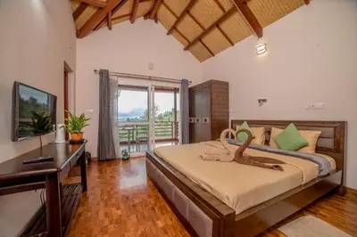 a bedroom with a bed and a desk and a window at Onella in Yedapalli