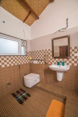 a bathroom with a sink and a toilet and a mirror at Onella in Yedapalli