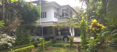 a truck parked in front of a white house at greenview homestay Mayyil in Parassinikadavu