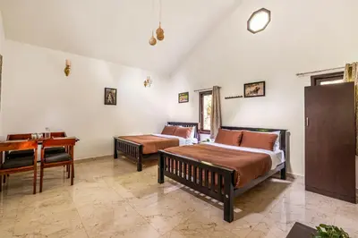 a bedroom with a bed and a desk and a table at Interlaken in Yedapalli