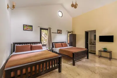 a bedroom with two beds and a flat screen tv at Interlaken in Yedapalli
