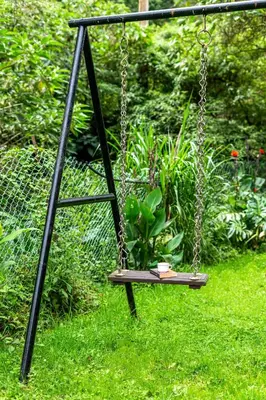 a swing in the grass with a book on it at Interlaken in Yedapalli