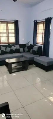 a living room with a couch and a table at KV Farm house in Malaiyāndipattanam