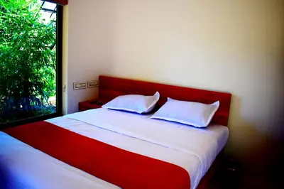a bedroom with a red and white bed with a window at Green Heaven Kuruva Wayanad in Chekadi