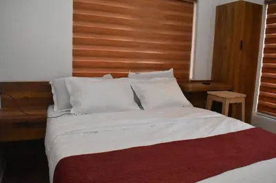 a bedroom with a large bed with a wooden headboard at Green Heaven Kuruva Wayanad in Chekadi