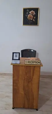 a wooden table with a sign that says reception at Holiday Apartments & Homestay in Sultan Bathery