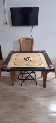 a ping pong table in front of a chair at Holiday Apartments & Homestay in Sultan Bathery