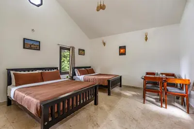 a bedroom with two beds and a table and a desk at Interlaken - 4 BR VIlla in Yedapalli