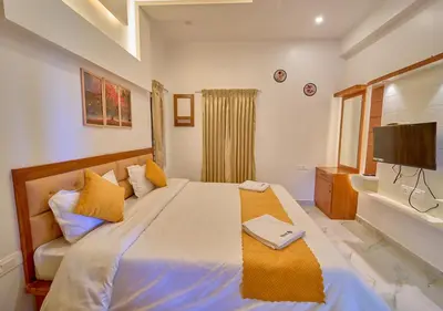 a bedroom with a large bed and a television at Central Homestay Ooty by VOYE HOMES Family-Friendly Budget Stay with Valley And Mountain Views in Ooty