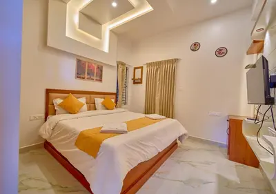 a bedroom with a large bed and a television at Central Homestay Ooty by VOYE HOMES Family-Friendly Budget Stay with Valley And Mountain Views in Ooty
