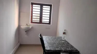 a bathroom with a table and a sink and a window at Aswathy Bhavan in Palakkad