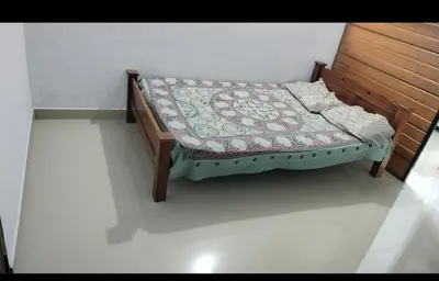 a bed with a quilt on it in a room at Aswathy Bhavan in Palakkad